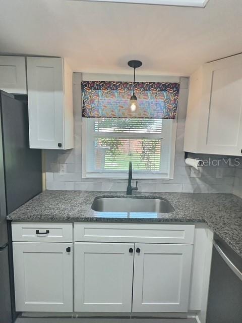 520 Jupiter Blvd NW, Palm Bay, FL 32907 - kitchen featuring stainless steel dishwasher, white cabinetry, and tasteful backsplash