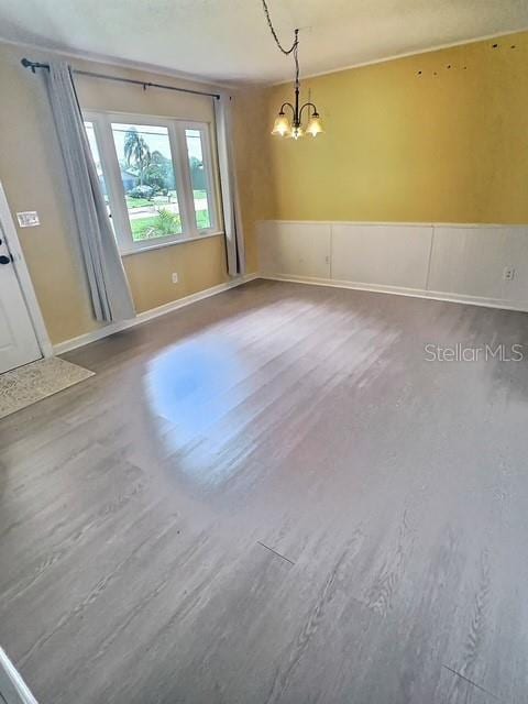 520 Jupiter Blvd NW, Palm Bay, FL 32907 - spare room featuring a chandelier, a wainscoted wall, and wood finished floors