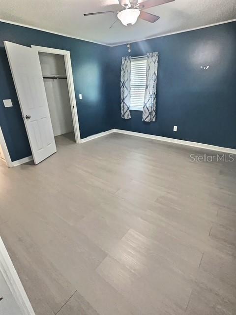 520 Jupiter Blvd NW, Palm Bay, FL 32907 - unfurnished bedroom featuring wood finished floors, ceiling fan, and a closet