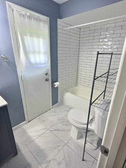 520 Jupiter Blvd NW, Palm Bay, FL 32907 - full bath with marble look tiles, vanity, and  shower combination