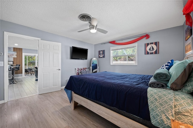 874 Acadia Rd, Venice, FL 34293 - bedroom featuring multiple windows, wood finished floors, a textured ceiling, and a ceiling fan