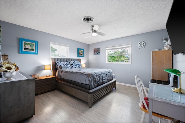 874 Acadia Rd, Venice, FL 34293 - bedroom with multiple windows, a textured ceiling, wood finished floors, and a ceiling fan