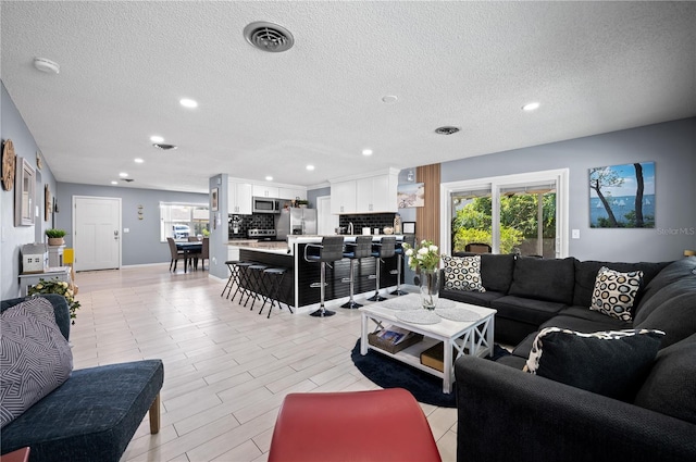 874 Acadia Rd, Venice, FL 34293 - living area featuring a textured ceiling, recessed lighting, and healthy amount of natural light