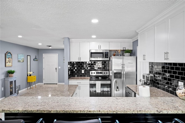 874 Acadia Rd, Venice, FL 34293 - kitchen with stainless steel appliances, white cabinets, decorative backsplash, a textured ceiling, and recessed lighting