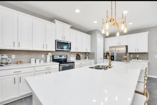 1870 Sawyer Palm Pl Unit 1870, Kissimmee, FL 34747 - kitchen with stainless steel appliances, a kitchen island with sink, a chandelier, backsplash, and white cabinets