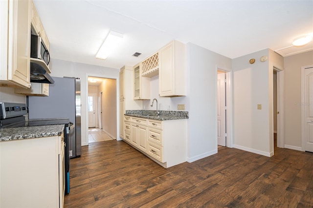 2531 Coral Ave, Kissimmee, FL 34741 - kitchen with appliances with stainless steel finishes, dark wood-style flooring, and stone counters