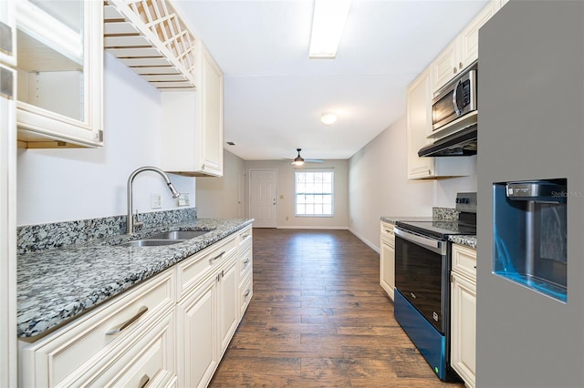 2531 Coral Ave, Kissimmee, FL 34741 - kitchen featuring appliances with stainless steel finishes, dark wood-style flooring, light stone countertops, ceiling fan, and glass insert cabinets