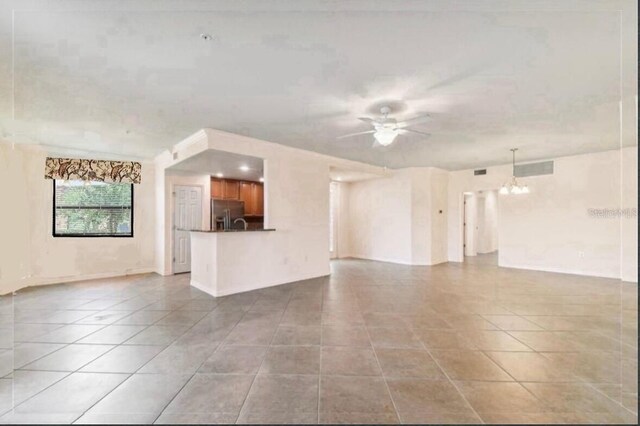 20080 Ragazza Cir Unit 102, Venice, FL 34293 - unfurnished living room featuring ceiling fan, light tile patterned flooring, and a chandelier