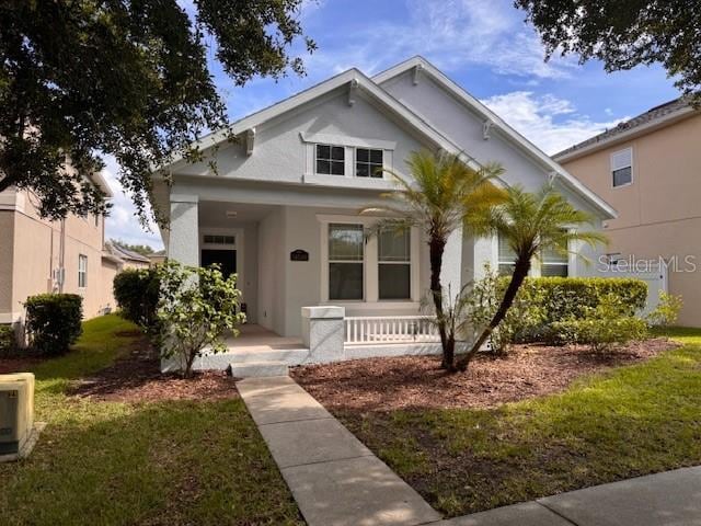 14548 Black Cherry Trl, Winter Garden, FL 34787 - bungalow-style home with stucco siding, covered porch, and a front lawn