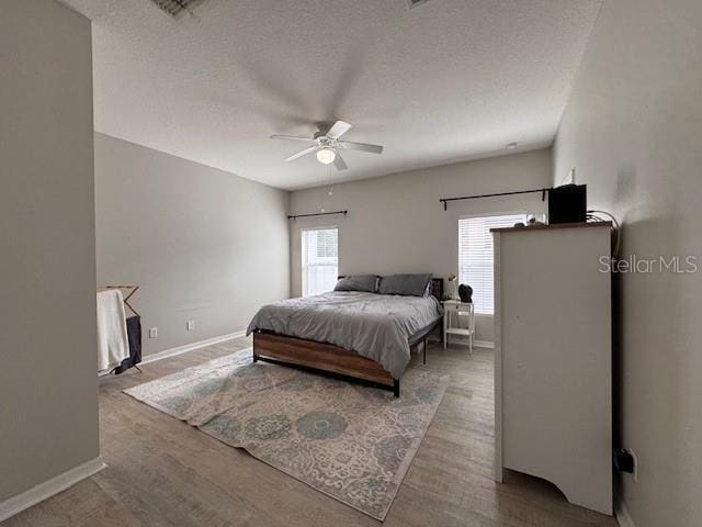 14548 Black Cherry Trl, Winter Garden, FL 34787 - bedroom featuring wood finished floors, a textured ceiling, and ceiling fan
