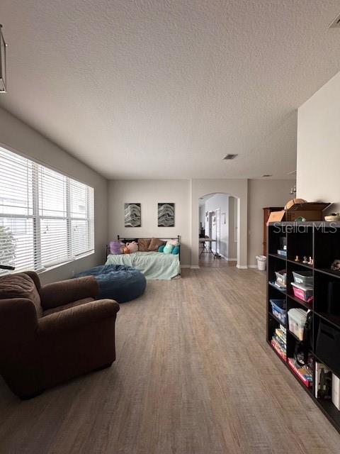 14548 Black Cherry Trl, Winter Garden, FL 34787 - living room featuring arched walkways, wood finished floors, and a textured ceiling