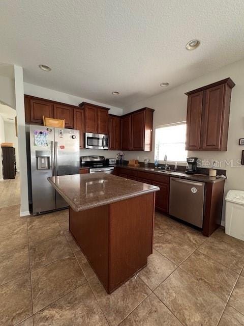 14548 Black Cherry Trl, Winter Garden, FL 34787 - kitchen featuring appliances with stainless steel finishes, a textured ceiling, a center island, tile patterned floors, and recessed lighting