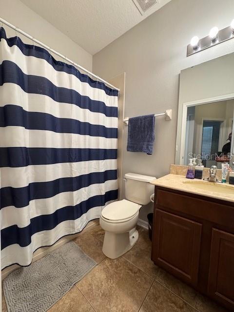 14548 Black Cherry Trl, Winter Garden, FL 34787 - full bathroom featuring vanity, tile patterned floors, a textured ceiling, and a shower with curtain