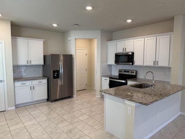 2602 Buena View Rd, Kissimmee, FL 34746 - kitchen with appliances with stainless steel finishes, tasteful backsplash, white cabinetry, dark stone counters, and recessed lighting