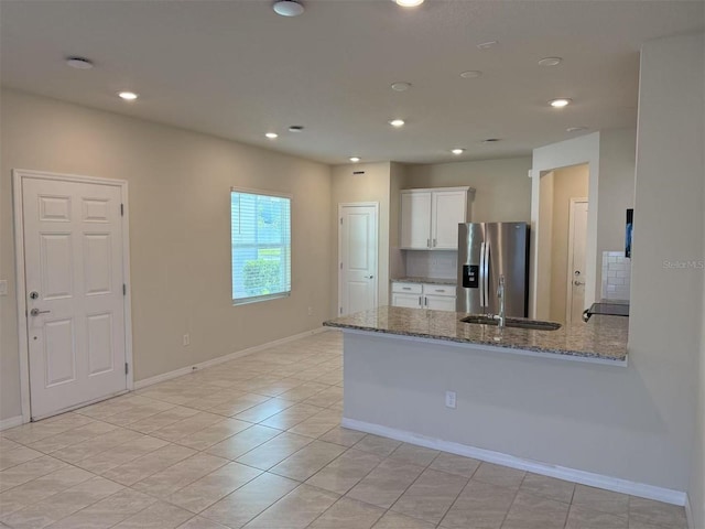 2602 Buena View Rd, Kissimmee, FL 34746 - kitchen featuring stainless steel fridge with ice dispenser, white cabinets, light stone counters, recessed lighting, and a peninsula