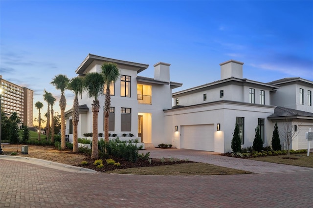 4162 Grande Brick Loop Unit 27, Orlando, FL 32837 - view of front of home with a chimney, decorative driveway, stucco siding, and an attached garage