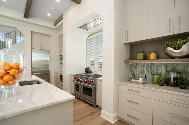 4162 Grande Brick Loop Unit 27, Orlando, FL 32837 - kitchen featuring light wood-style flooring, high quality appliances, beamed ceiling, light stone counters, and open shelves