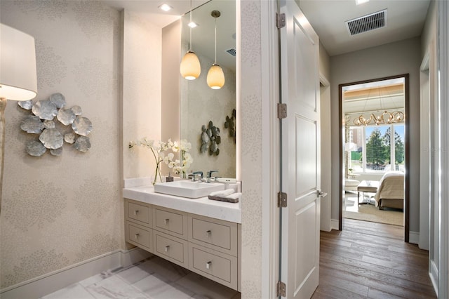 4162 Grande Brick Loop Unit 27, Orlando, FL 32837 - bathroom with vanity, ensuite bath, wood finished floors, and wallpapered walls