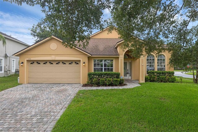 2534 Double Tree Pl, Oviedo, FL 32766 - view of front of house with stucco siding, a front lawn, decorative driveway, and an attached garage