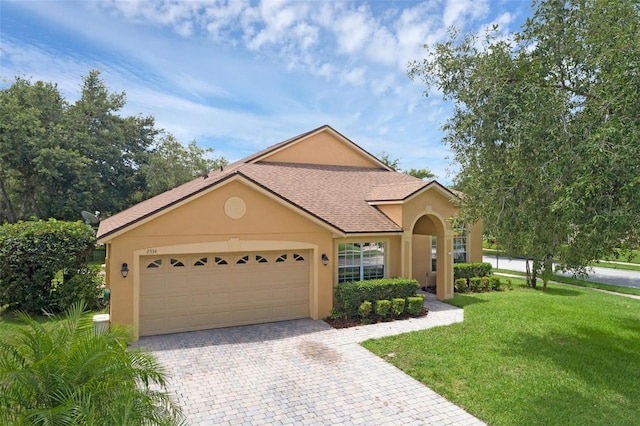 2534 Double Tree Pl, Oviedo, FL 32766 - view of front of house with stucco siding, a front yard, an attached garage, decorative driveway, and a shingled roof