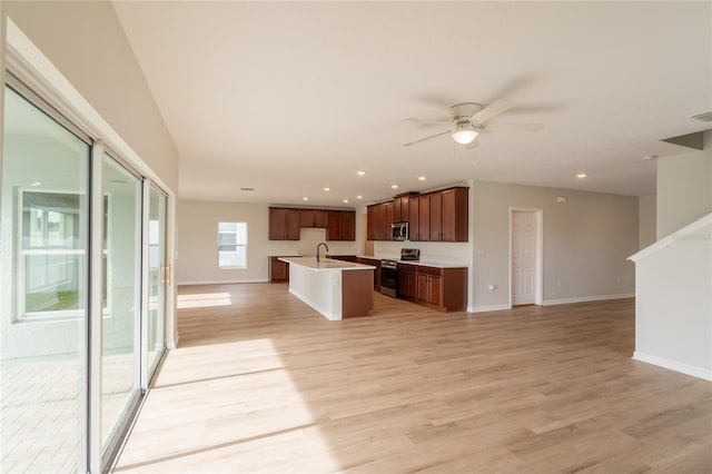 3840 Fescue St, Clermont, FL 34714 - kitchen featuring appliances with stainless steel finishes, open floor plan, a kitchen island with sink, recessed lighting, and light wood finished floors
