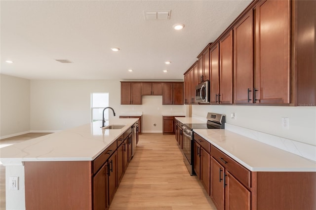 3840 Fescue St, Clermont, FL 34714 - kitchen featuring stainless steel appliances, light wood-style flooring, recessed lighting, a large island, and light stone countertops