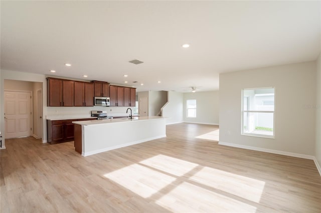 3840 Fescue St, Clermont, FL 34714 - kitchen with appliances with stainless steel finishes, light wood finished floors, an island with sink, recessed lighting, and open floor plan