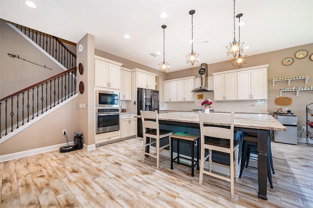 3546 Mediterra Dr, Clermont, FL 34711 - kitchen with stainless steel appliances, wall chimney range hood, light wood-type flooring, white cabinets, and recessed lighting