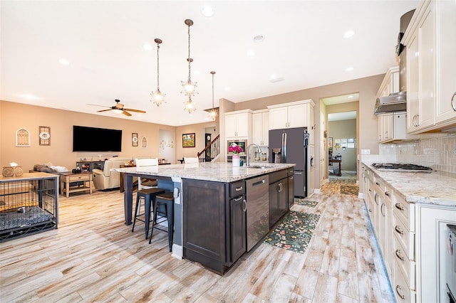 3546 Mediterra Dr, Clermont, FL 34711 - kitchen with appliances with stainless steel finishes, light wood finished floors, ceiling fan, decorative backsplash, and recessed lighting