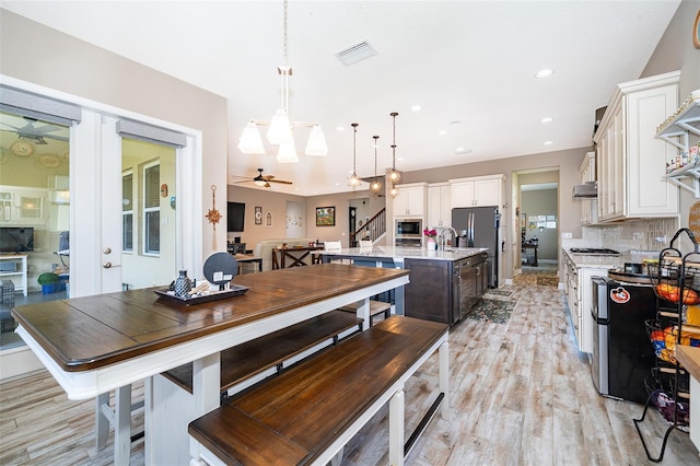 3546 Mediterra Dr, Clermont, FL 34711 - dining room featuring a ceiling fan, stairway, light wood-type flooring, recessed lighting, and a chandelier