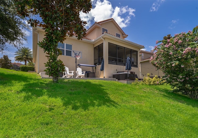 3546 Mediterra Dr, Clermont, FL 34711 - rear view of house featuring a lawn, stucco siding, and a sunroom