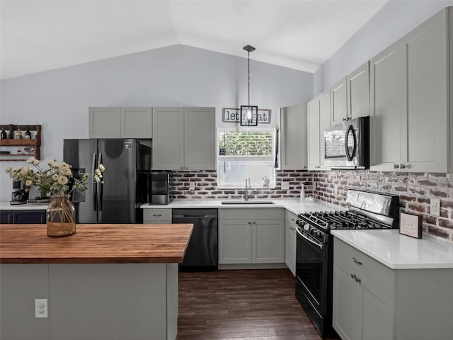 15718 Carriage Hill Ct, Clermont, FL 34711 - kitchen with black appliances, butcher block counters, vaulted ceiling, decorative backsplash, and dark wood finished floors