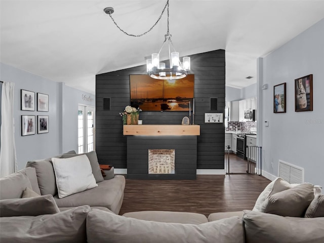 15718 Carriage Hill Ct, Clermont, FL 34711 - living room with a chandelier, dark wood-type flooring, vaulted ceiling, a large fireplace, and wood walls