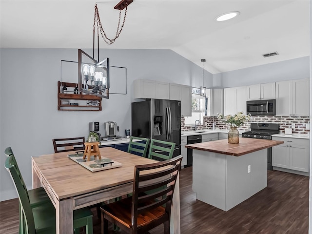 15718 Carriage Hill Ct, Clermont, FL 34711 - kitchen with appliances with stainless steel finishes, wood counters, vaulted ceiling, tasteful backsplash, and dark wood-style flooring