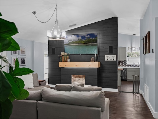 15718 Carriage Hill Ct, Clermont, FL 34711 - living area with a chandelier, dark wood-style flooring, lofted ceiling, and a fireplace