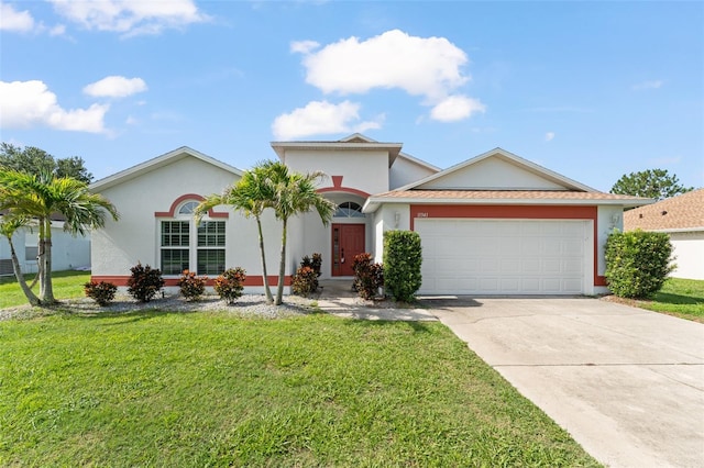 11341 Autumn Wind Loop, Clermont, FL 34711 - mediterranean / spanish house featuring an attached garage, concrete driveway, a front lawn, and stucco siding