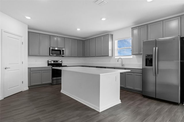 617 Hitch Loop, Saint Cloud, FL 34772 - kitchen featuring appliances with stainless steel finishes, gray cabinets, a kitchen island, dark wood-type flooring, and recessed lighting