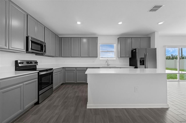 617 Hitch Loop, Saint Cloud, FL 34772 - kitchen with appliances with stainless steel finishes, gray cabinetry, healthy amount of natural light, dark wood-type flooring, and recessed lighting
