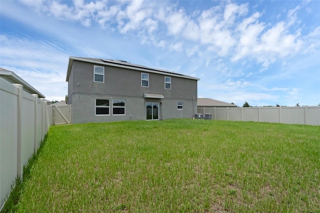 617 Hitch Loop, Saint Cloud, FL 34772 - rear view of house with stucco siding, a fenced backyard, and solar panels