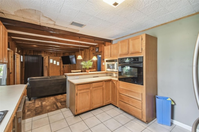 1108 W Minnehaha Ave, Clermont, FL 34711 - kitchen with black oven, wooden walls, a peninsula, white microwave, and light countertops