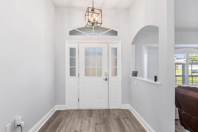 198 Porto Velho St, Punta Gorda, FL 33983 - entrance foyer featuring a chandelier, wood finished floors, arched walkways, and a towering ceiling