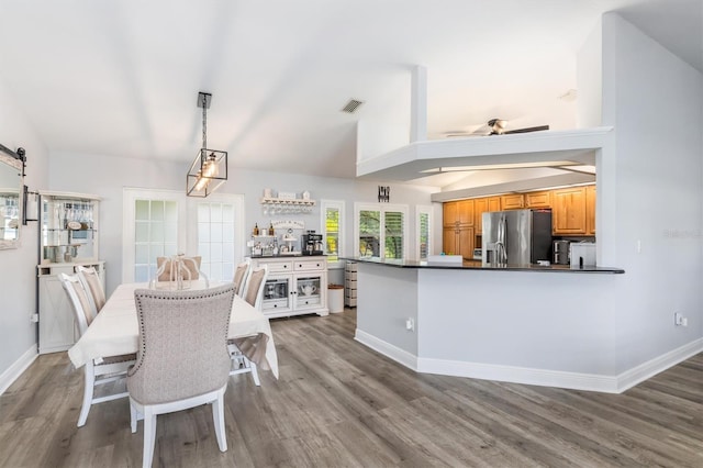 198 Porto Velho St, Punta Gorda, FL 33983 - kitchen featuring stainless steel refrigerator with ice dispenser, dark countertops, wood finished floors, a barn door, and lofted ceiling