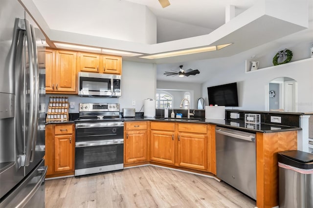 198 Porto Velho St, Punta Gorda, FL 33983 - kitchen featuring appliances with stainless steel finishes, vaulted ceiling, ceiling fan, a peninsula, and light wood-type flooring