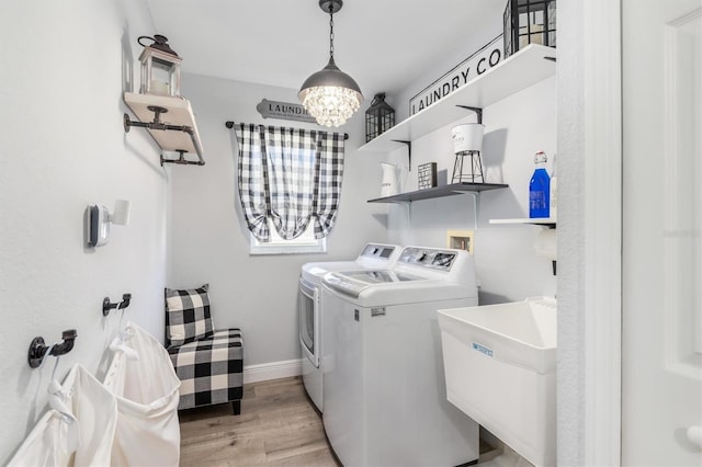 198 Porto Velho St, Punta Gorda, FL 33983 - laundry area with separate washer and dryer, light wood-style flooring, and a chandelier