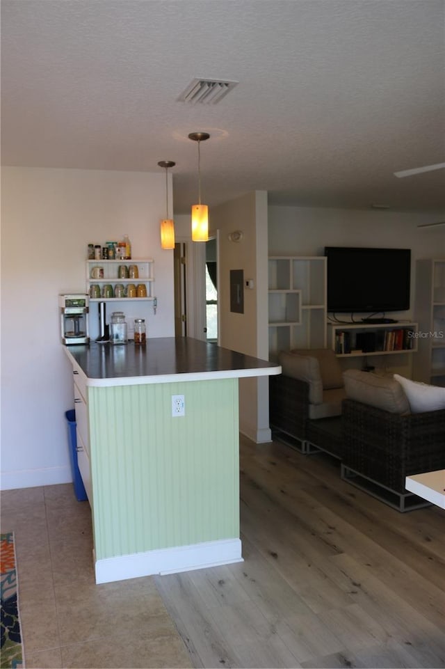 686 S Atlantic Ave Unit 1-8, Cocoa Beach, FL 32931 - kitchen featuring dark countertops, wood finished floors, a textured ceiling, and pendant lighting