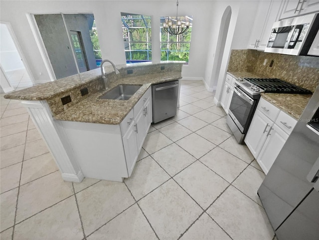 4615 River Overlook Dr, Valrico, FL 33596 - kitchen with appliances with stainless steel finishes, light tile patterned floors, arched walkways, backsplash, and white cabinets