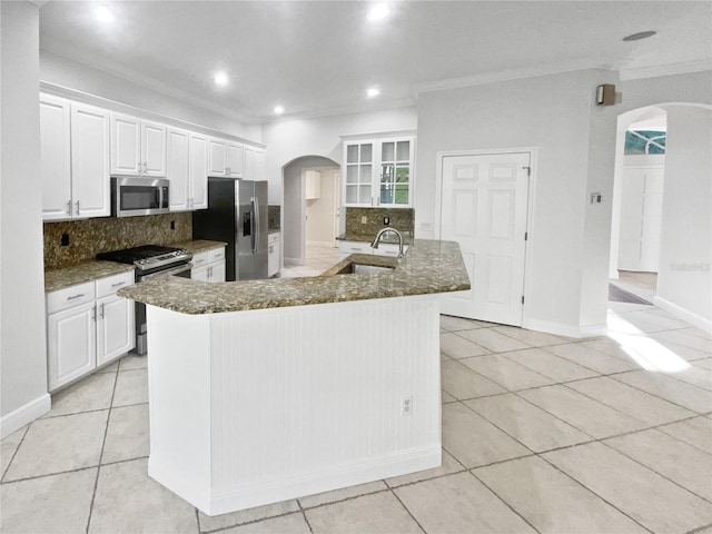 4615 River Overlook Dr, Valrico, FL 33596 - kitchen featuring appliances with stainless steel finishes, arched walkways, light tile patterned floors, decorative backsplash, and recessed lighting