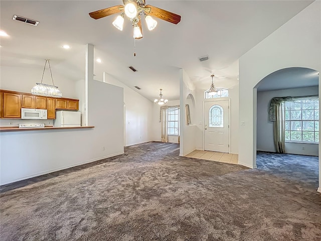 16634 Pine Timber Ave, Montverde, FL 34756 - unfurnished living room with light colored carpet, vaulted ceiling, a ceiling fan, arched walkways, and a chandelier