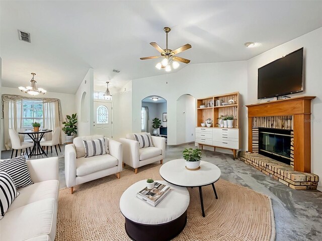 16634 Pine Timber Ave, Montverde, FL 34756 - living room featuring arched walkways, lofted ceiling, a fireplace, a ceiling fan, and a chandelier