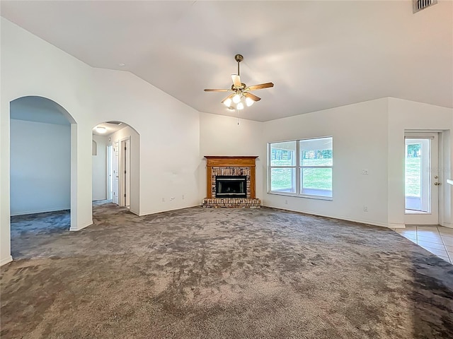 16634 Pine Timber Ave, Montverde, FL 34756 - unfurnished living room featuring a ceiling fan, vaulted ceiling, carpet floors, a brick fireplace, and arched walkways
